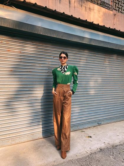 Another shot of the green sweater look. The combination of the puff sleeves, pussy-bow collar, and relaxed trousers creates a fun, eclectic vibe.