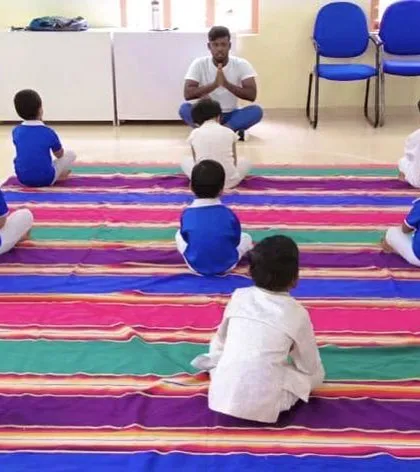 A peaceful moment as children sit in a circle for a guided yoga and meditation exercise. These practices help enhance happiness and strength from within, providing tools for focus and calm.