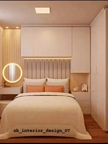 A warm and inviting bedroom with integrated wardrobes and a vanity nook. The circular backlit mirror and soft lighting create a cozy and glamorous corner.