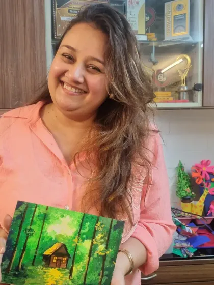 This student created a peaceful, dreamy forest scene with a cozy cabin. Her beautiful smile reflects the calm and soulful feeling that comes from getting lost in the world of painting.