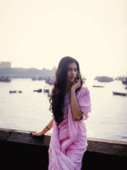 A soft, dreamy portrait by the sea wall. The hazy light and gentle pose give this photo a very calming and pleasant vibe.