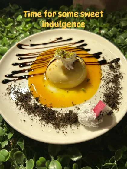 Time for some sweet indulgence. This exquisitely plated dessert features a delicate sphere on a bed of mango puree, drizzled with chocolate and sprinkled with cookie crumble.