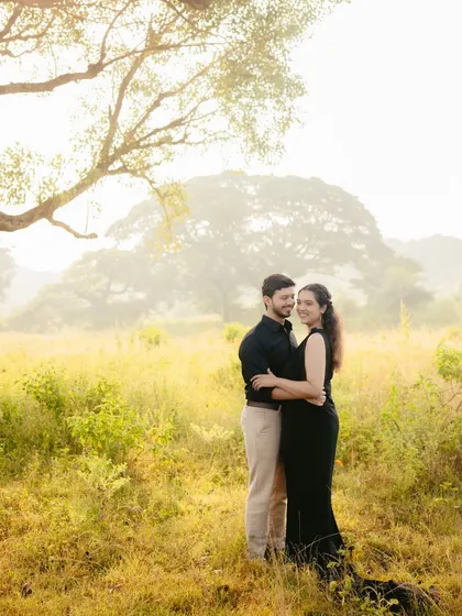 A dramatic and romantic shot from a pre-wedding session. I styled the couple in elegant black outfits to create a beautiful contrast against the soft, misty morning light and the golden field.