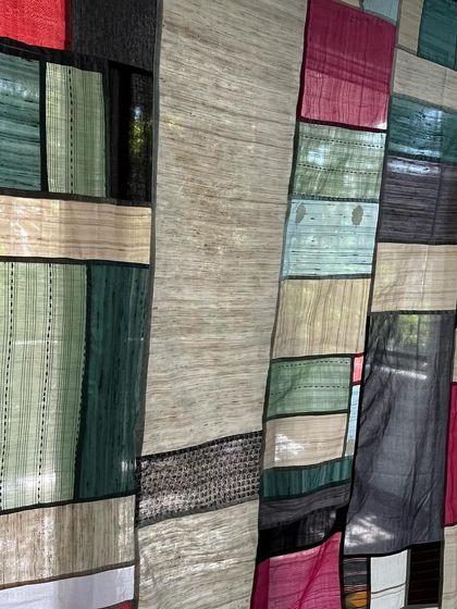 A close-up of the Pojagi-style room divider, showing how the light filters through the different semi-transparent fabrics.