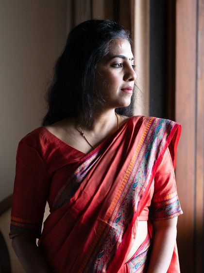 A self-portrait in a red saree, a moment of reflection. My work is about finding the light in the quiet darkness and revealing the truth of who we are.