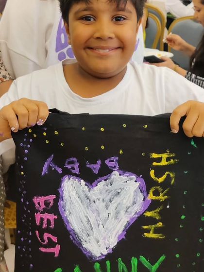 A young guest created a heartfelt message on a tote bag, showing that all ages can participate and contribute at a family event.