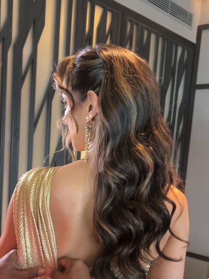 A glamorous half-ponytail with highlights, a chic and modern look for a reception.