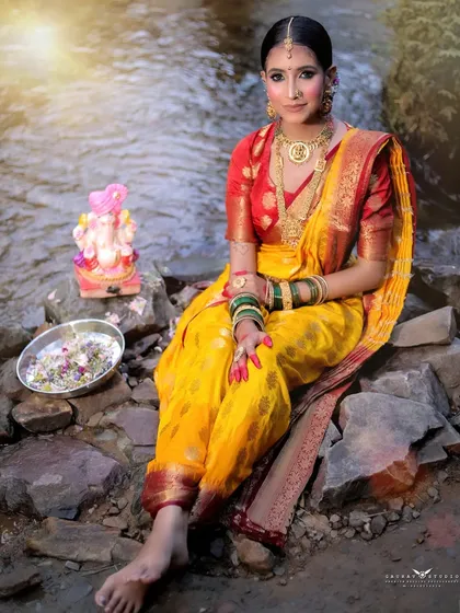 A beautiful seated pose, capturing the vibrant yellow of the saree against the natural backdrop.