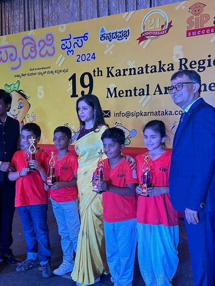 A group of our young state award winners holding their trophies. Their smiles show the confidence they have gained through competitive mental arithmetic.
