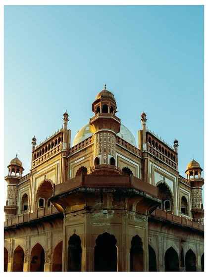 An angular view of Safdarjung's Tomb at golden hour, the warm light highlighting the intricate details of its domes and arches.