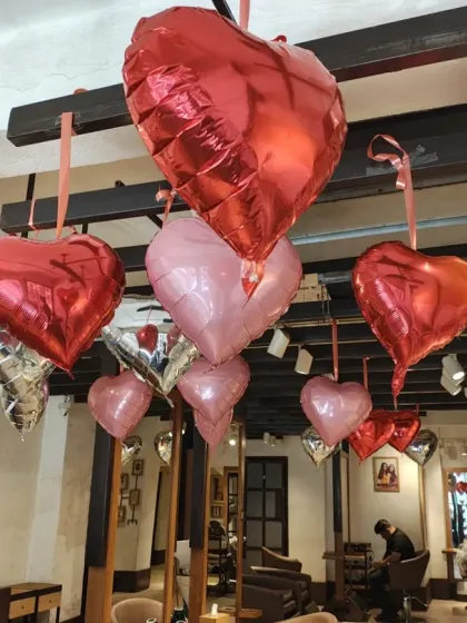 Another perspective of the salon's main floor, showing how the heart-shaped balloons create a canopy of color over the customer areas. This is a great way to make a client's experience feel more special.