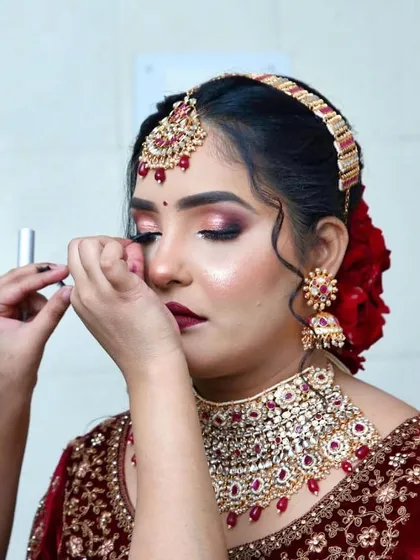 Precision is key for a flawless bridal look. Here you can see the careful application of lashes, an essential step to making the eyes pop in photos and in person.