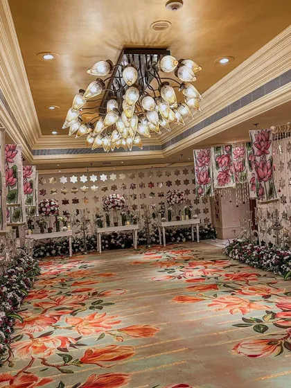 This Sangeet at ITC Maurya featured a unique floral-printed carpet that covered the entire ballroom floor, complemented by hand-painted floral panels and elegant lounge seating.