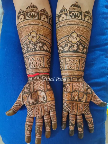A clear, full view of a bridal mehndi with prominent elephant figures on the palms and the couple's names written in Hindi.