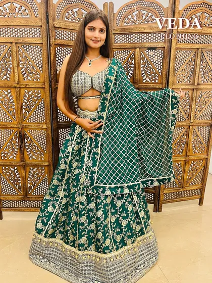 The full view of the emerald green lehenga, showing the beautiful floral and lattice pattern work.