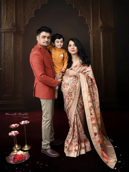 A complete family portrait with a traditional Indian aesthetic. The composition, with the family framed by an archway, creates a feeling of warmth and togetherness.