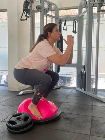 Working on balance and leg strength with squats on a BOSU ball. This advanced variation challenges stability and engages more muscles than a standard squat.