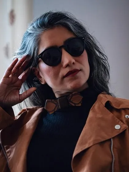 A close-up on the details, showing the wooden bow tie and sunglasses that complete this rock-inspired outfit.