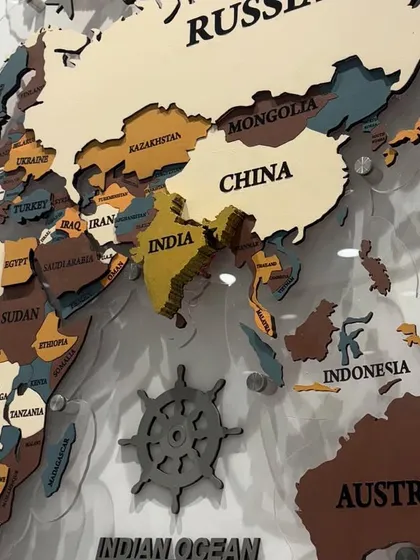 A close-up on the Asia and Australia section of the world map, showing the precision of the country name engravings and layered construction.