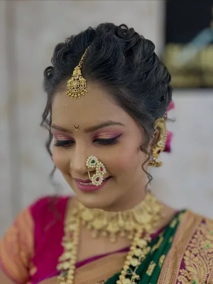 The intricate details of the bridal makeup and hairstyle, including the delicate curls and flawless base.