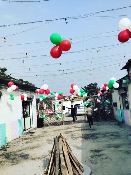 This outdoor area at a cafe was decorated with red, white, and green balloon bunches strung overhead to create a festive atmosphere for the Christmas season.