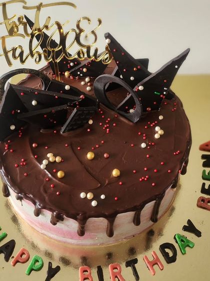 A "Forty & Fabulous" milestone birthday cake. This is my classic chocolate cake with a rich ganache drip, topped with abstract chocolate shards and colourful lettering for a fun, celebratory feel.