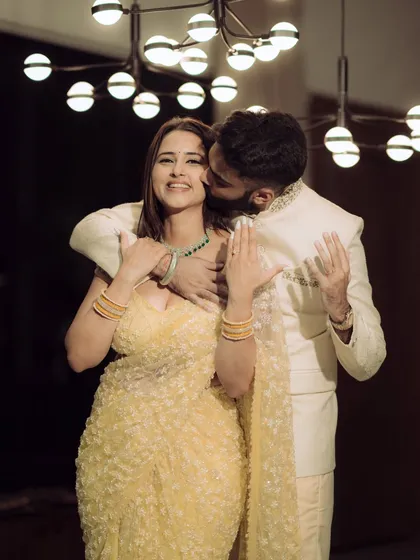 A moment of pure joy and laughter during an indoor engagement celebration. The warm lighting and genuine expressions make this a perfect blend of candid emotion and cinematic style.