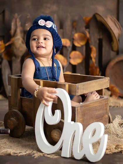 Our rustic theme is a popular choice for first birthdays. This little boy looks adorable in his denim overalls and winter hat.