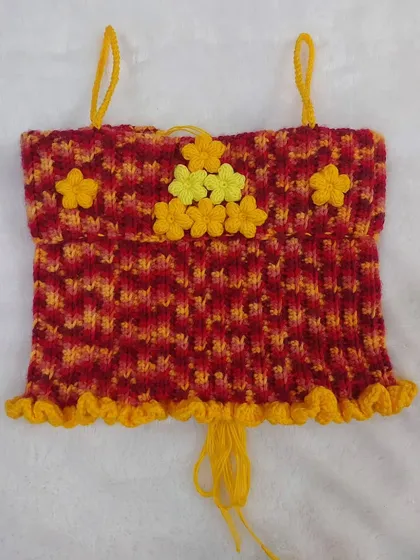 Another flat-lay view of the Daisy Babe Top, highlighting the texture and cheerful flower arrangement.