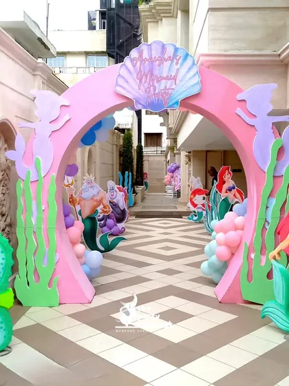 We designed this enchanting 'Under the Sea' entrance arch for a mermaid-themed party. Featuring characters from The Little Mermaid, custom seaweed cutouts, and a seashell welcome sign, it transports guests to a magical underwater kingdom.