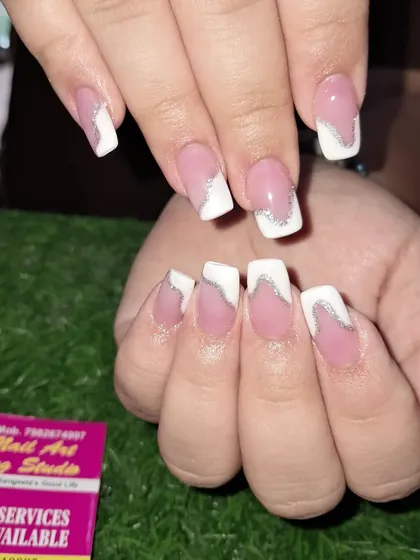 A modern twist on the French manicure with an abstract white design and a silver glitter line on square nails.