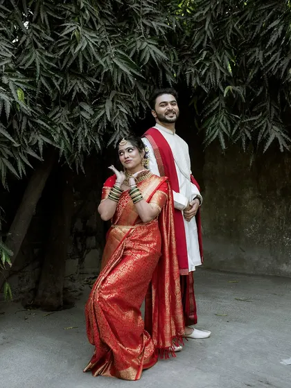 A fun and playful pose from a Maharashtrian wedding. The bride's expressive gesture adds a touch of personality to this traditional couple portrait.