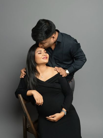 A classic pose of love and affection. The partner's gentle kiss on the forehead is a timeless symbol of care and devotion during this special journey.