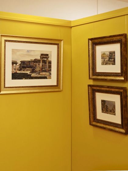A view of our gallery with artworks displayed on a vibrant yellow wall. Let the silence of the gallery speak to you.