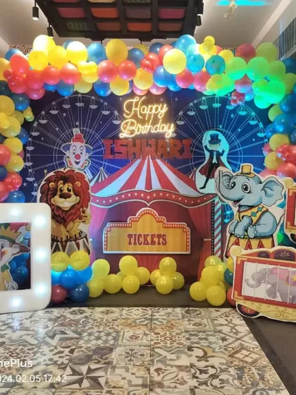 This carnival theme for a 10th birthday shows how we can handle large, detailed setups. The backdrop includes a Ferris wheel design, circus tent elements, and character cutouts, all framed by a colorful balloon arch and a light-up marquee number.