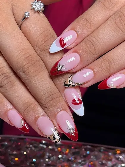 Red lips, red tips. A playful and glamorous set featuring red and white French tips, leopard print, and hand-painted lip motifs.