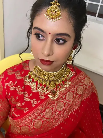 A close-up of Navya's reception makeup. We went for a classic winged liner and a bold red lip to match her saree.