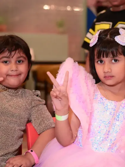 Two friends making peace signs for the camera, enjoying the party together.
