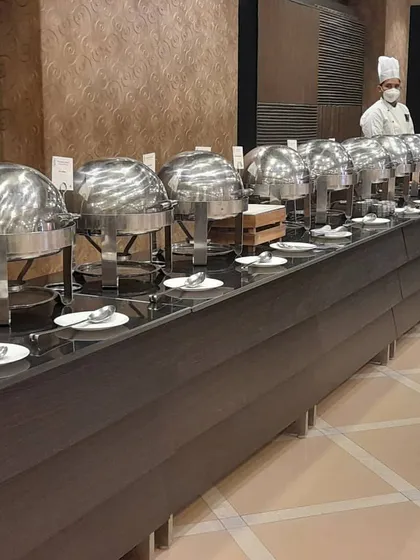 A long buffet line at a hotel or banquet hall, with a chef ensuring everything is in order. This demonstrates my experience in working in professional, large scale venues.