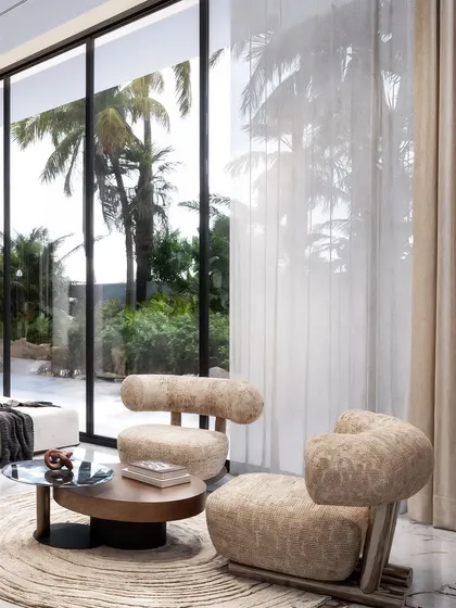A close-up of unique, sculptural armchairs, rendered to show their unusual form and textured fabric.