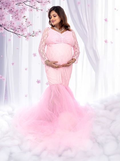 A beautiful full-length shot of a mom-to-be in a pink gown, surrounded by a soft cloud effect for a heavenly feel.
