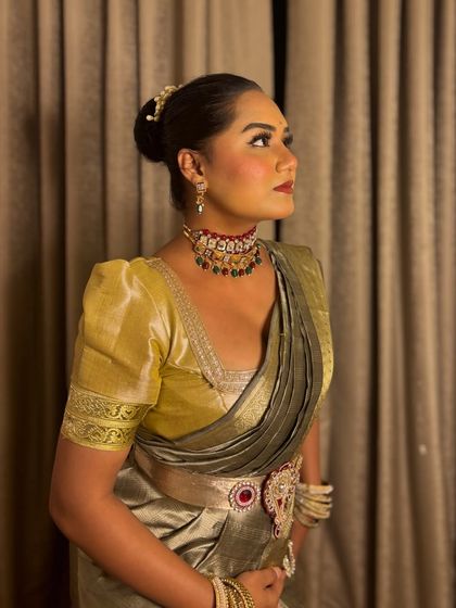 A profile shot capturing the elegance of the saree and the intricate details of the choker and earrings.