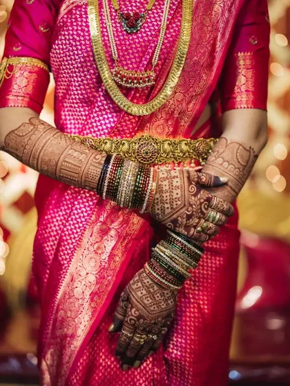 The beauty of dark shades. A deep, mature henna stain looks stunning paired with a vibrant pink Kanjivaram saree and traditional gold jewelry.