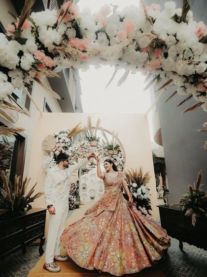 A twirl under a floral arch. I love capturing movement, and this shot of the groom twirling his bride shows off the beautiful flow of her lehenga and the joy of the moment.