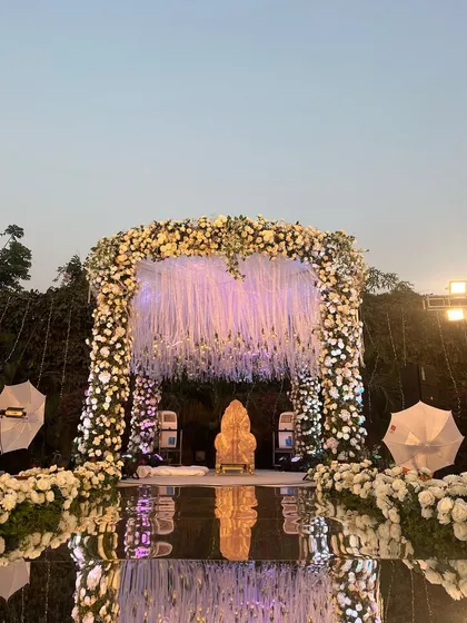 The same mirrored aisle mandap seen at dusk, where the lighting creates a dramatic and romantic reflection, enhancing the beauty of the setup.
