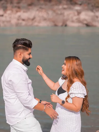 A joyful and candid moment between the couple by the river, full of laughter and natural interaction.