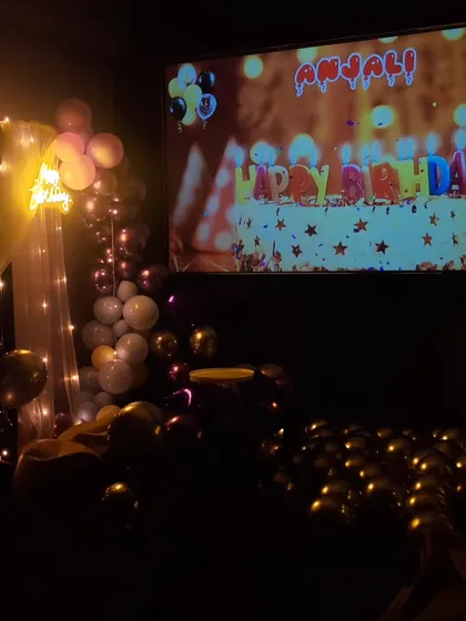You can even play a personalized birthday video on the big screen. This photo shows a custom 'Happy Birthday' message displayed during a celebration, making it extra special.
