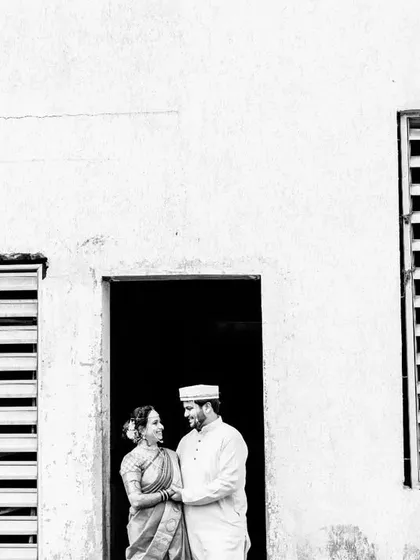 A minimalist black and white portrait of the couple framed in a doorway, creating a simple yet powerful composition.