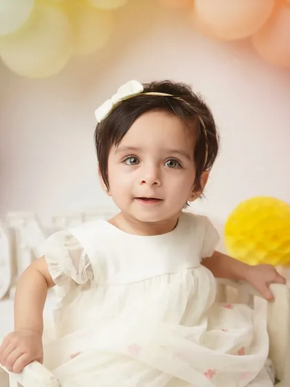 A close-up portrait of the birthday girl, her big, curious eyes looking right at the camera. These are the faces you'll want to remember forever.