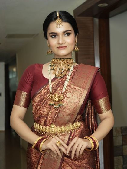 This full-length view displays how the makeup, hair, and traditional attire come together. The bride's posture exudes grace, and her makeup provides a radiant focal point.